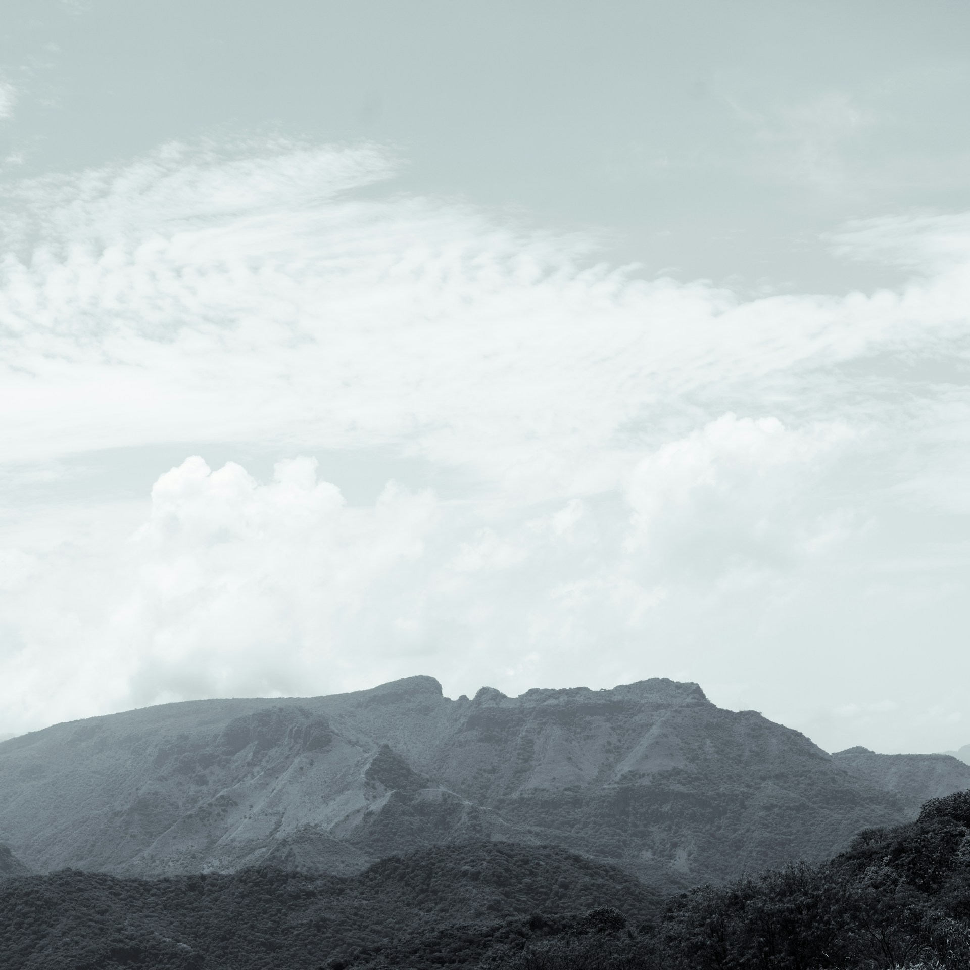 A serene landscape with rolling hills under a soft, cloudy sky, inviting a peaceful pause.