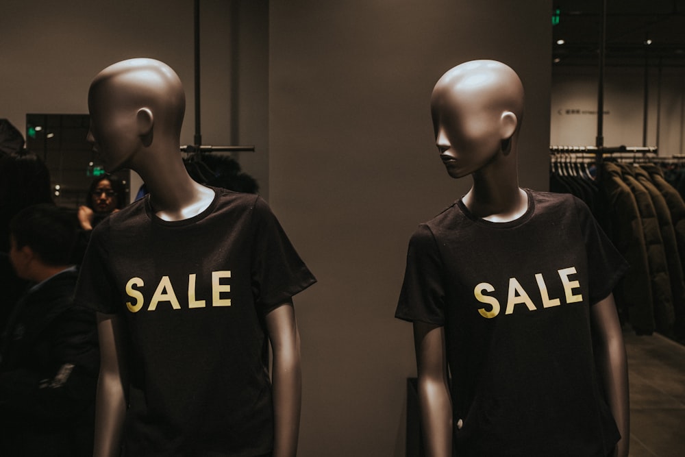 deux mannequins avec des t-shirts à col rond graphiques noirs Soldes