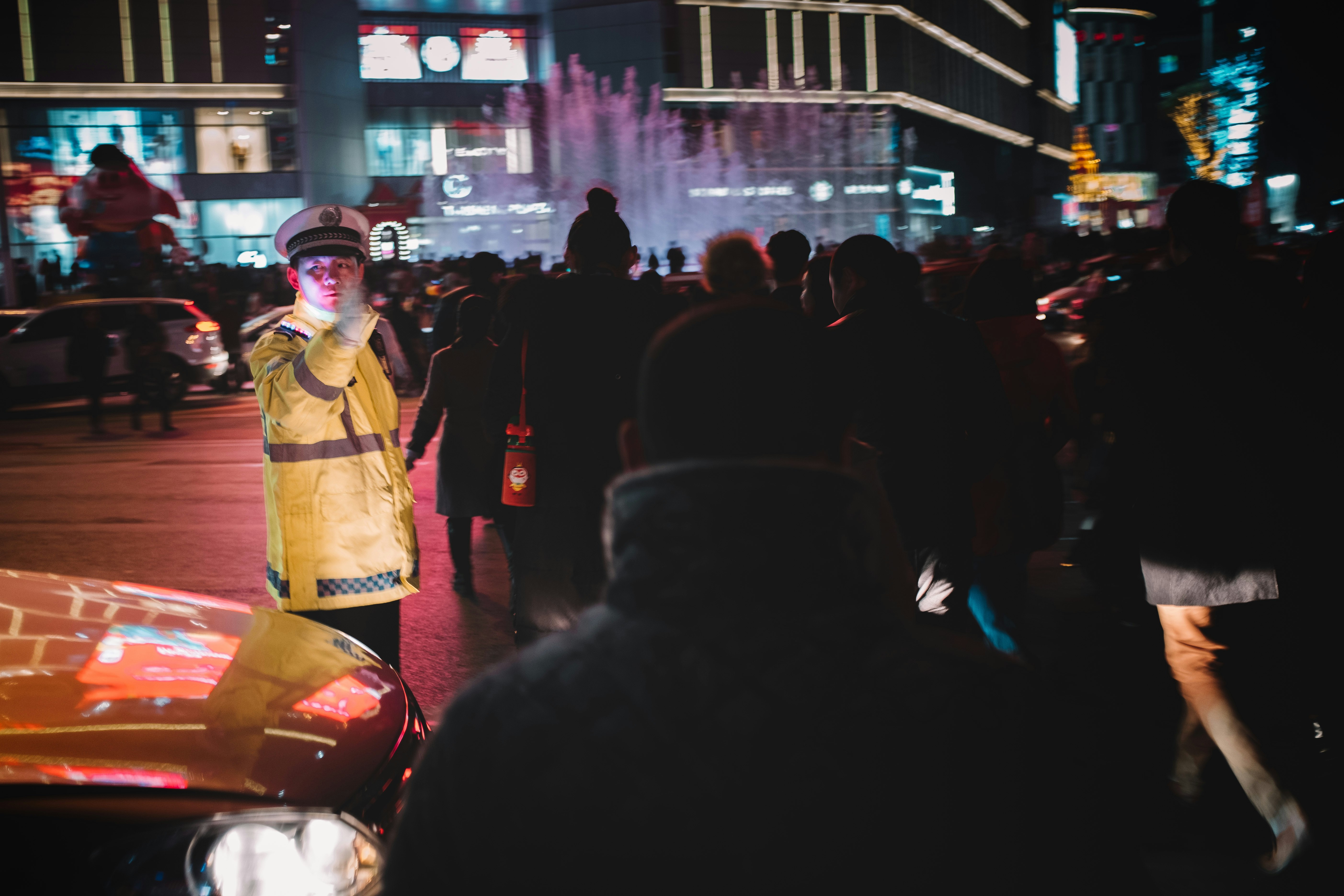 traffic officer in yellow coat guiding people crossing the street