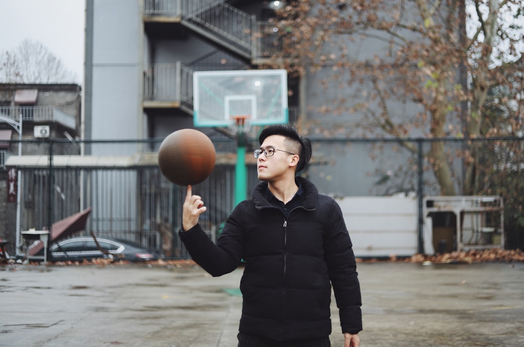 man standing and playing with basketball ball