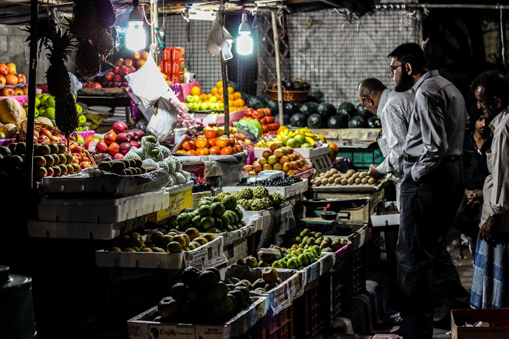 man standing in front of fruit stall