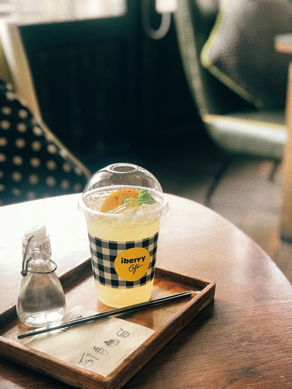 clear plastic cup with lid on brown wooden tray