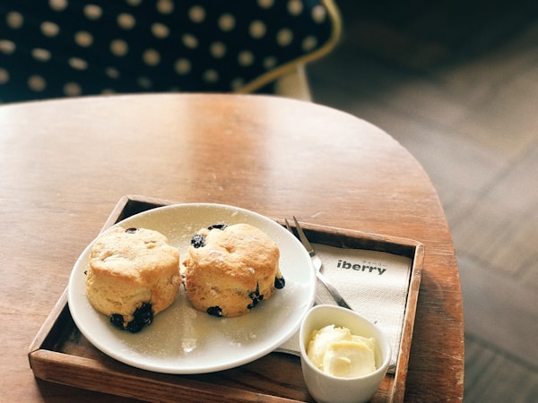 Raisins bread on plate beside butter in bowl