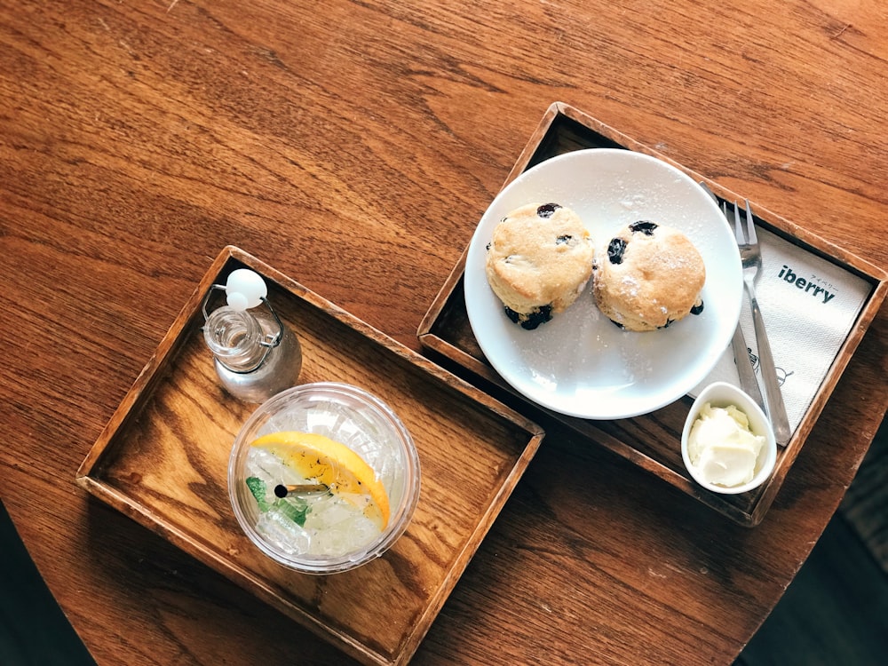 filled glass on tray beside pastry on white plate