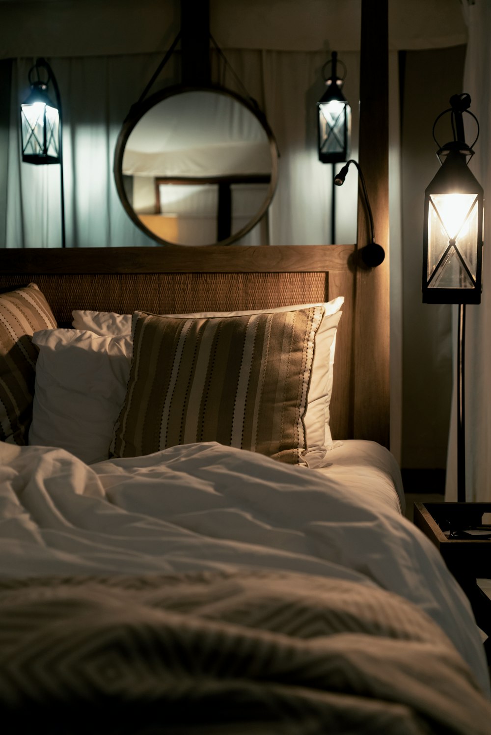 multicolored pillows on bed and lighted pendant lamp inside room