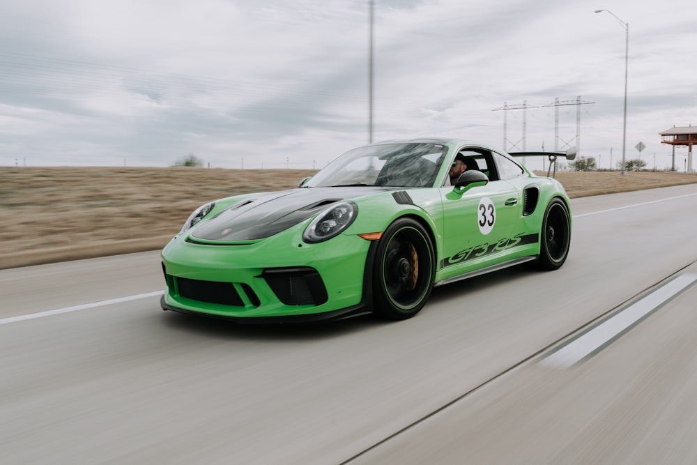 green coupe in middle of road