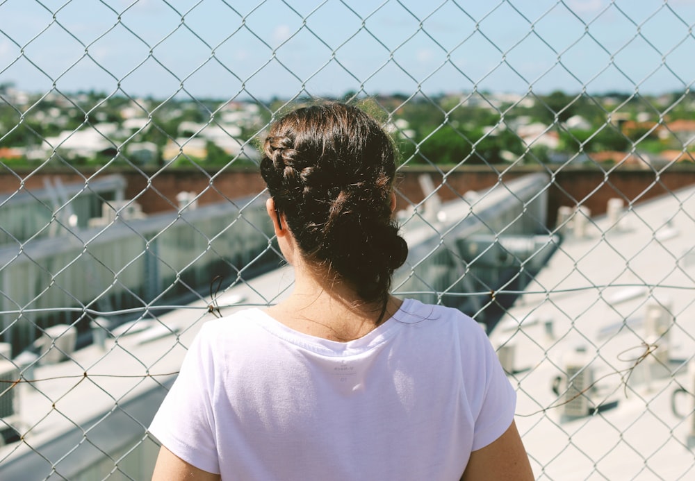 person facing back on chainlink fence