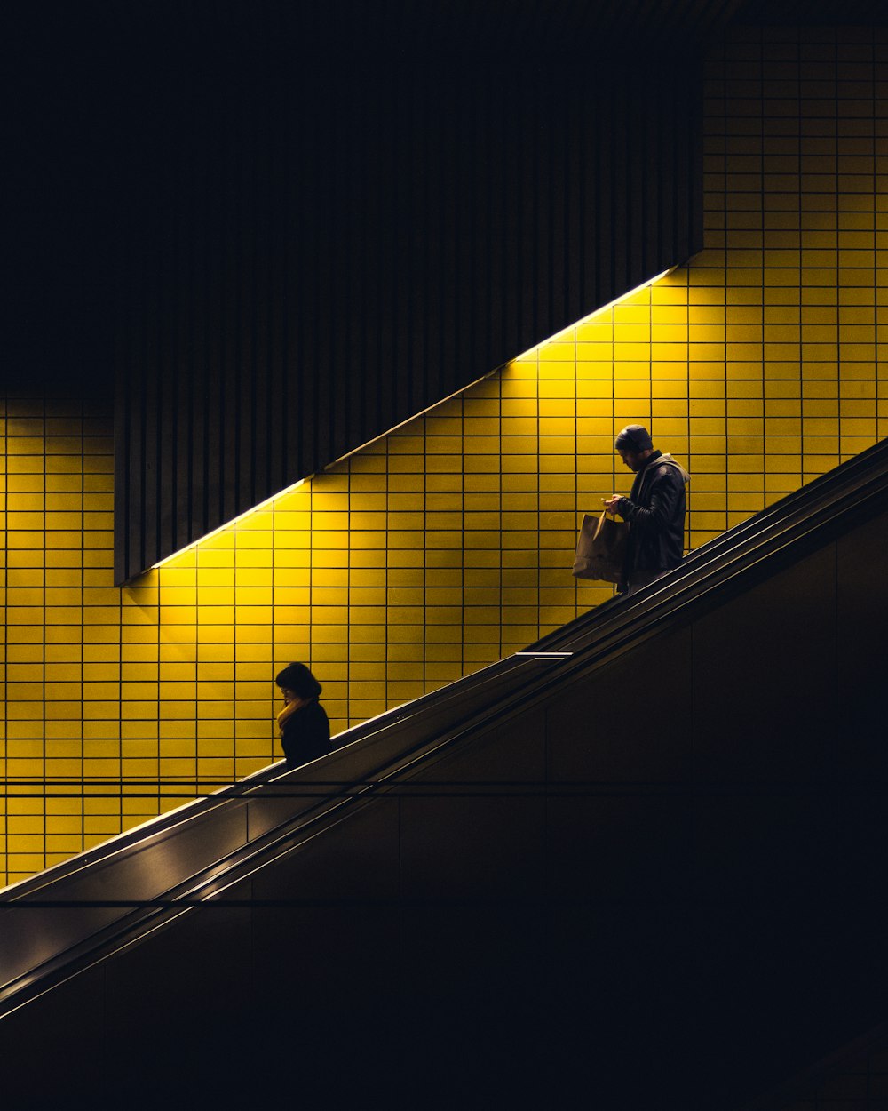 Dos personas en la escalera a través de la pared amarilla