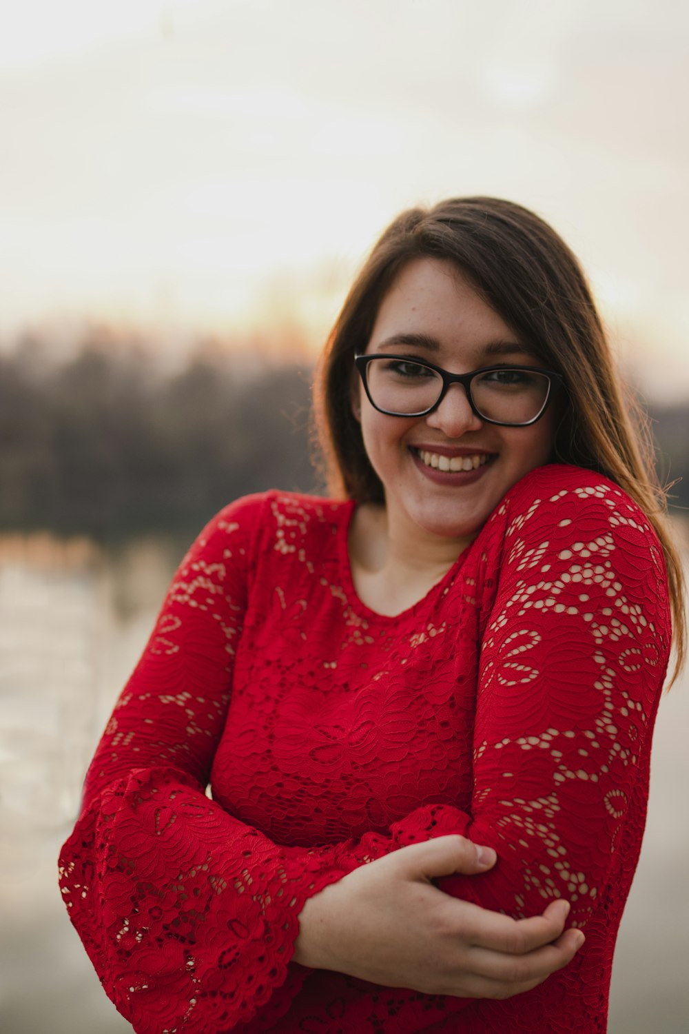 smiling woman wearing red long-sleeved lace top