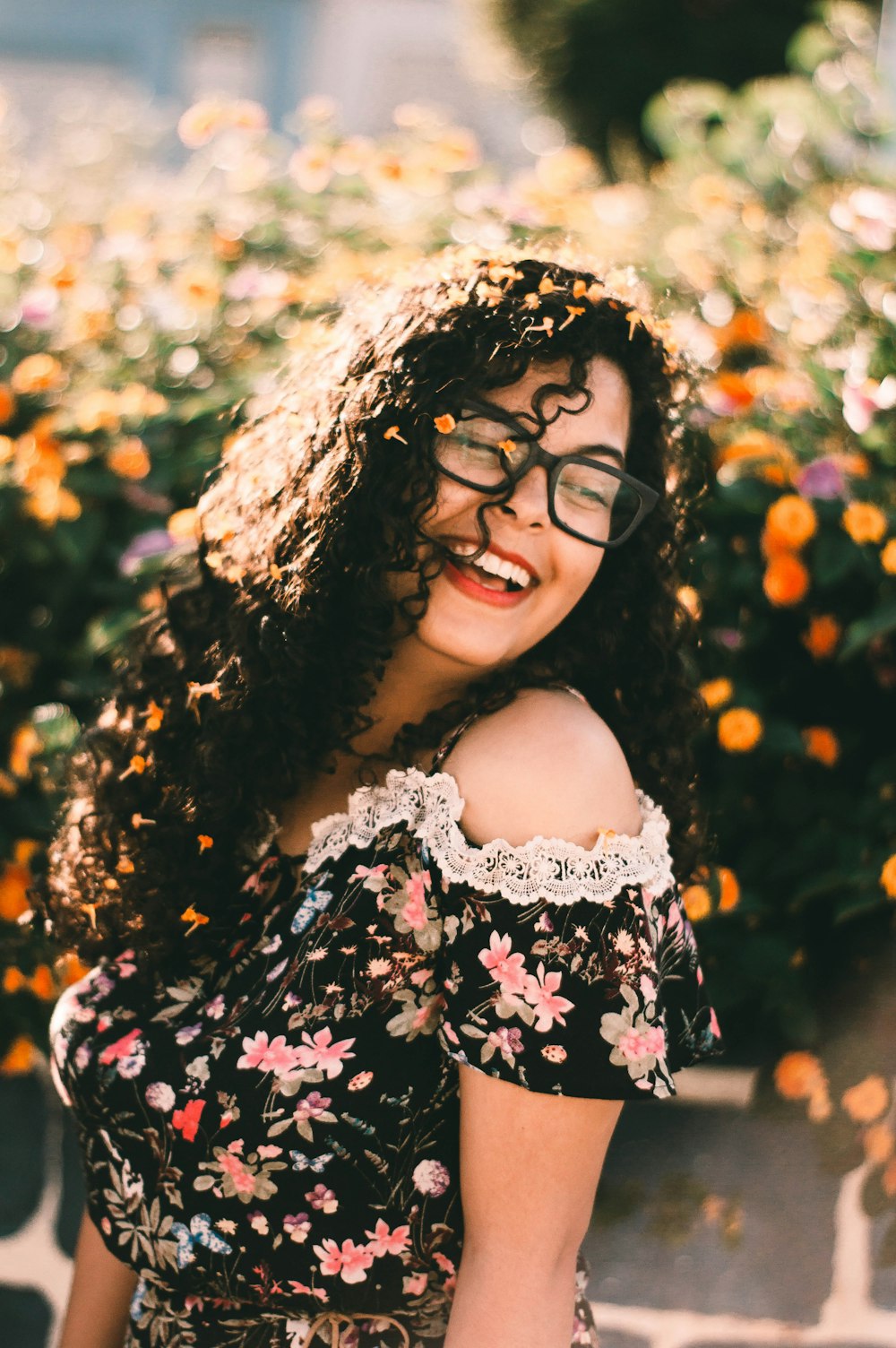 smiling woman standing near flowers