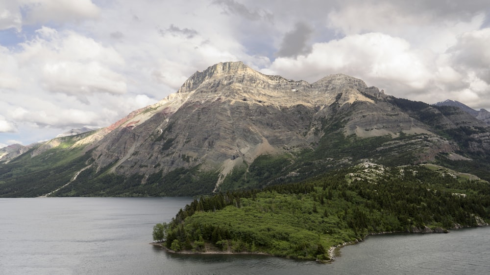 landscape photo of mountains near body of water under cloudy sky