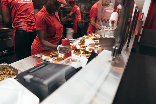 Two burger machines and one fry machine working simultaneously in a restaurant kitchen.
