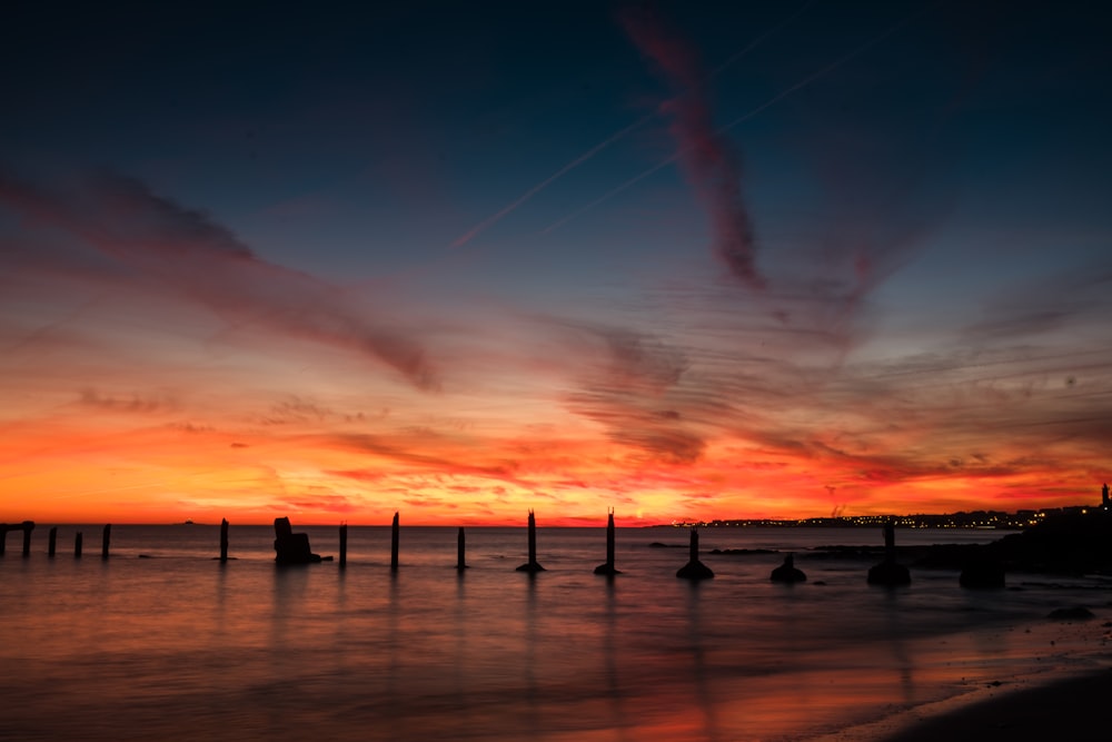 silhouette of poles on body of water