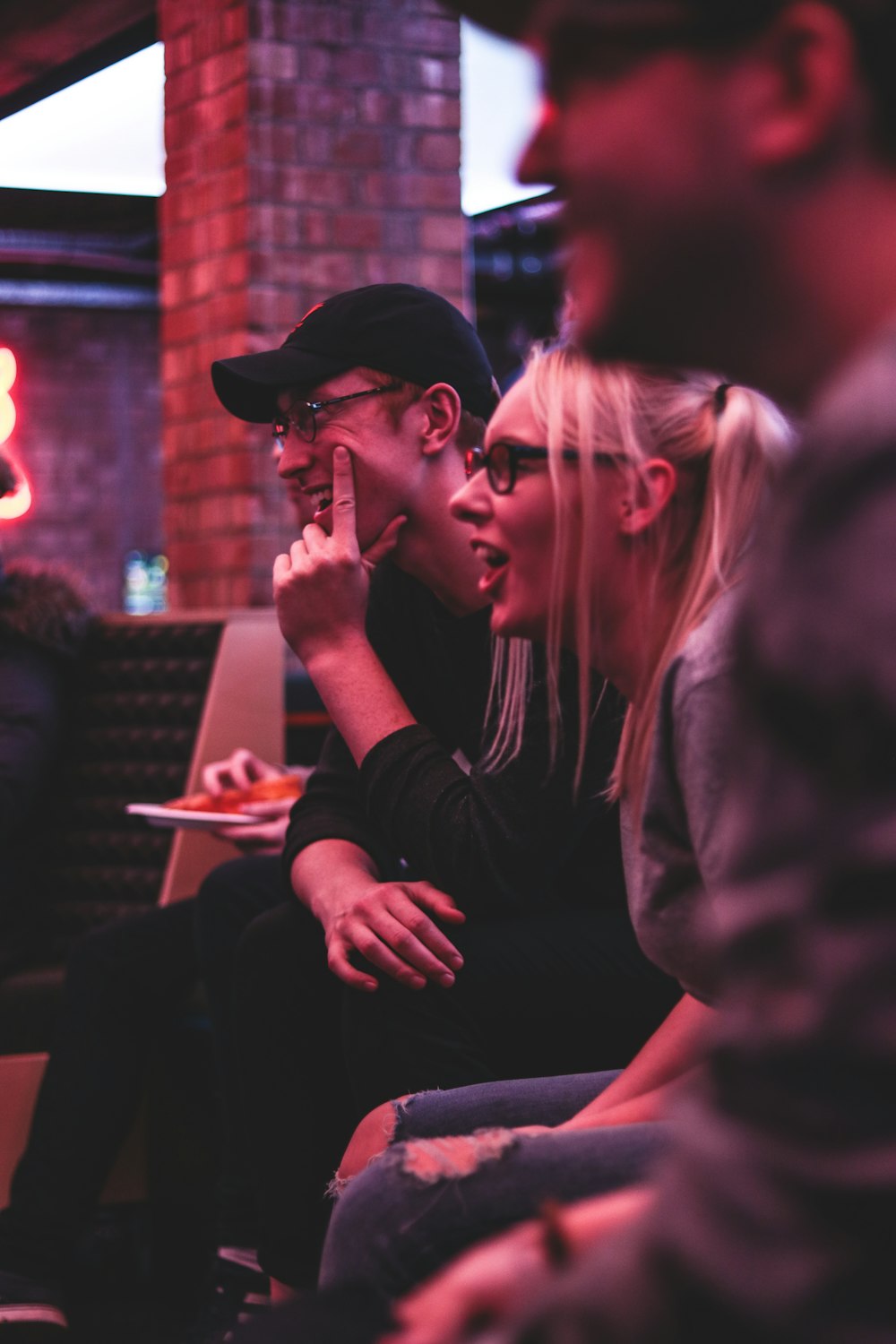 woman sitting between two men smiling