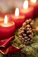 A cozy arrangement of festive holiday candles glowing softly on a rustic wooden table.