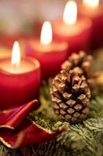A cozy arrangement of festive holiday candles glowing softly on a rustic wooden table.