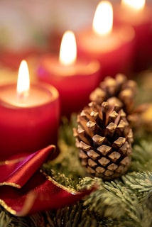 Cozy Advent wreath with candles and pine cones on a rustic wooden table.