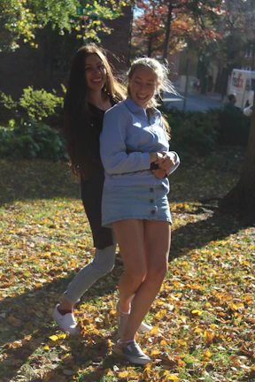 A young person and an elderly person sharing a warm embrace in a sunlit park.
