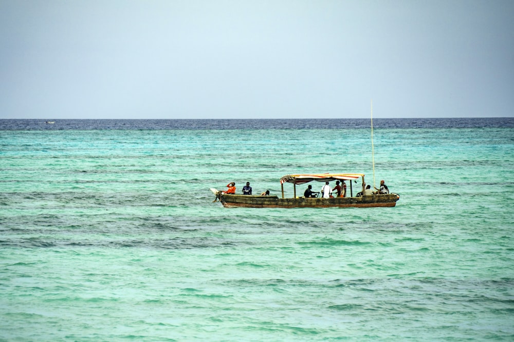 Grupo de pessoas a andar de barco rodeado por um corpo de água