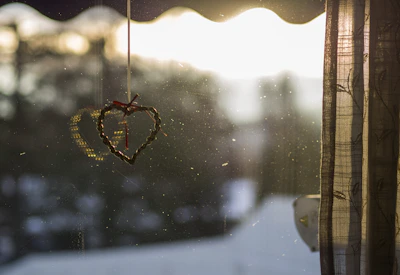 Sunlight shining through a delicate handmade suncatcher hanging by a window.