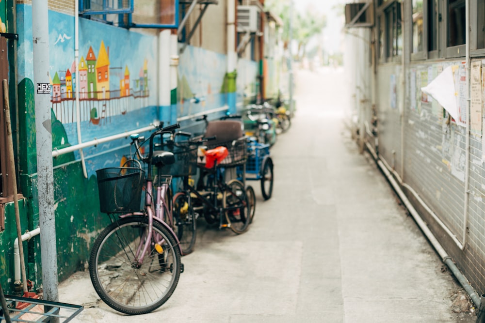 selective focus photography of bicycle parking beside wall