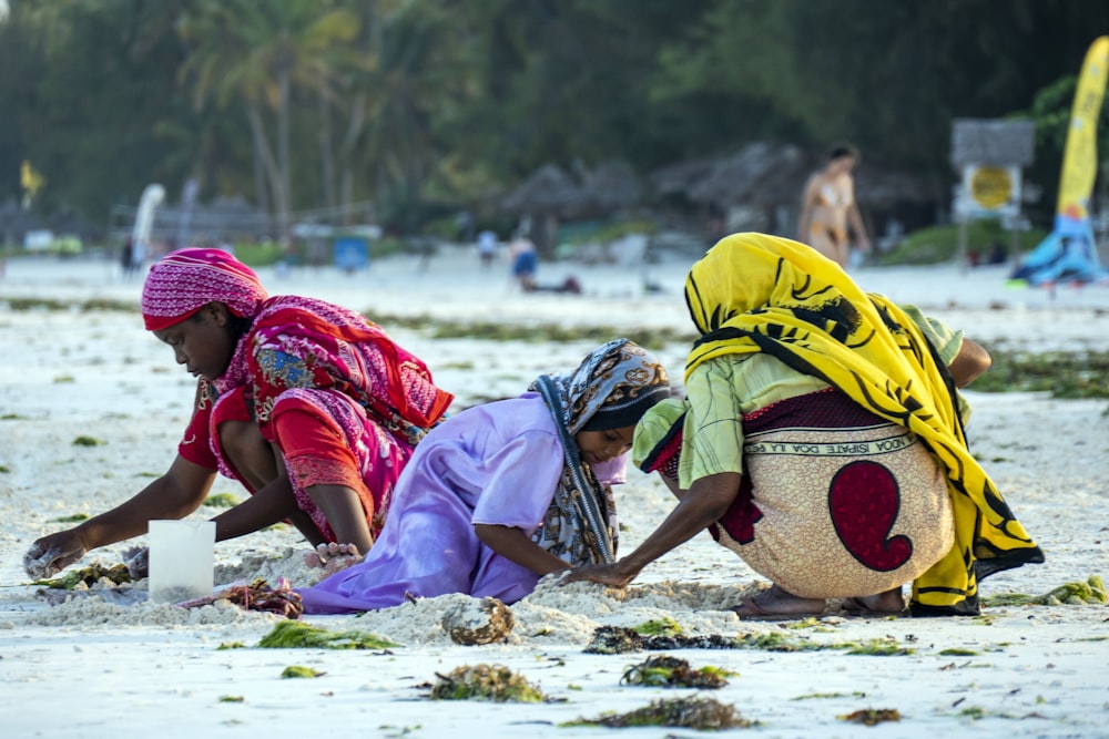 three person on shore during daytime