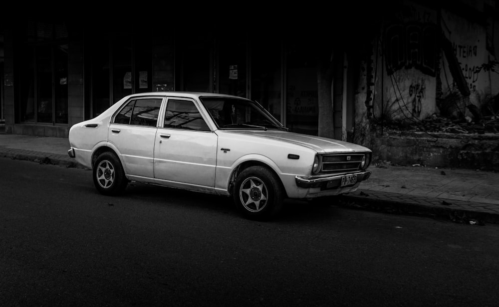 grayscale photography of sedan parking