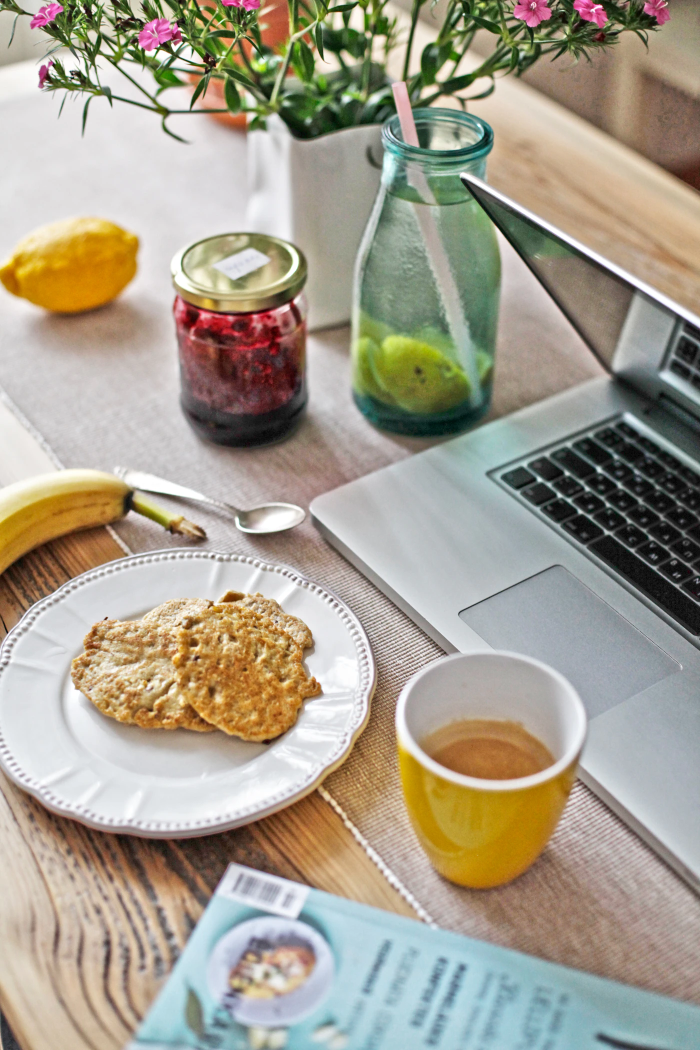 Cookies beside a laptop and a plant on a light table