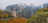 Man admiring the painted monasteries of Bukovina surrounded by autumn colors.