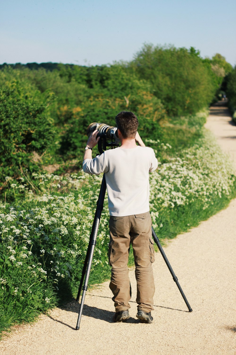 man in white sweatshirt holding camera