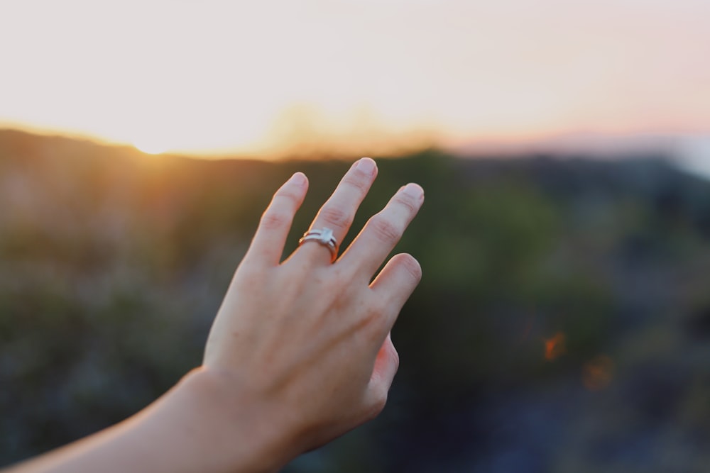 person wearing gold-colored ring