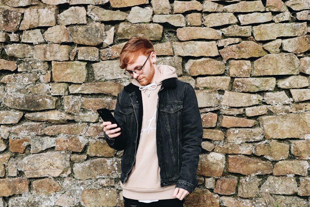 man looking down while holding smartphone