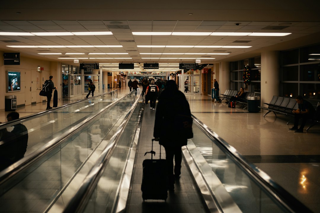 空港で荷物を持って移動する旅行者のイメージ