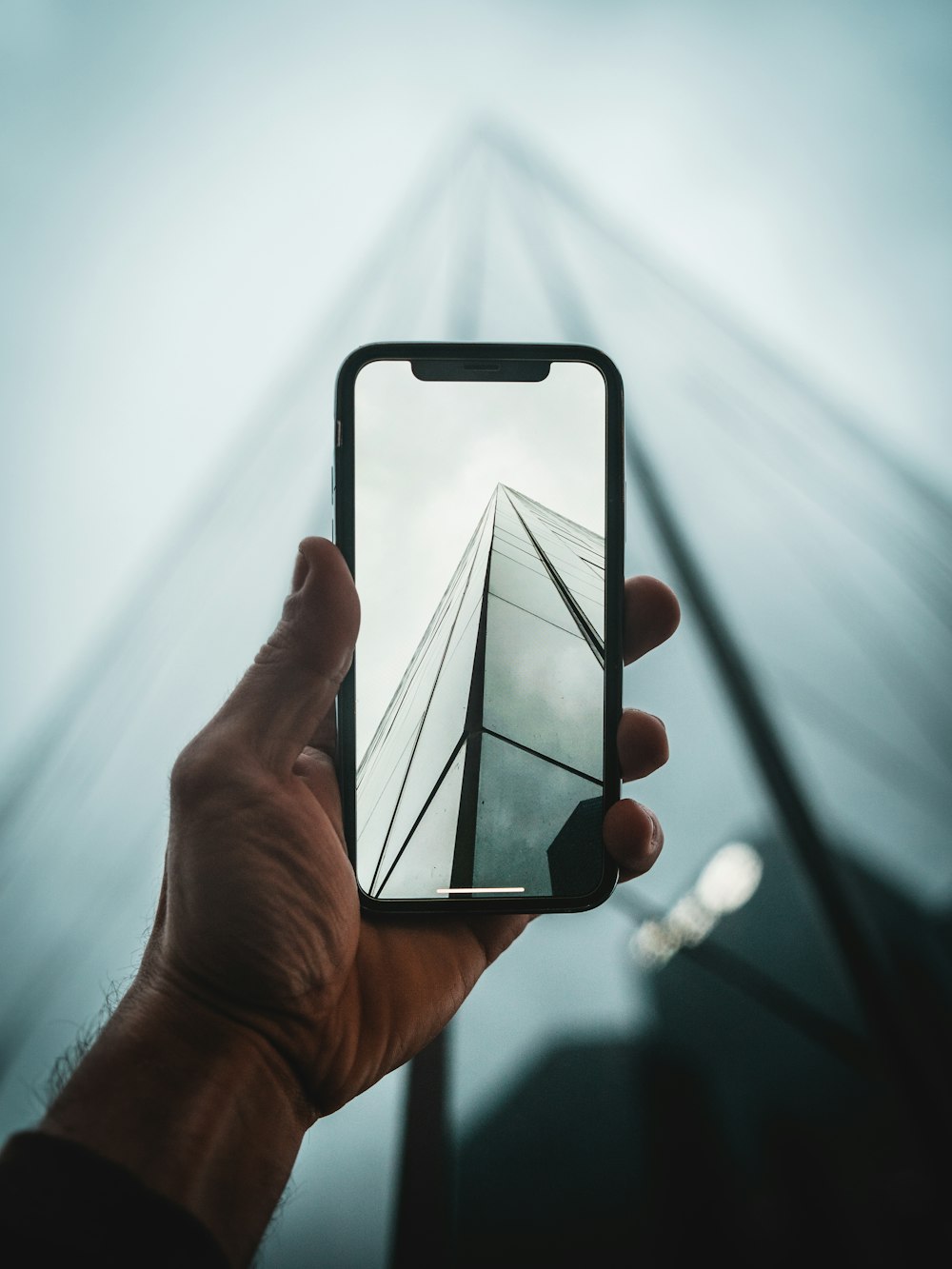 person taking a photo of building using smartphone