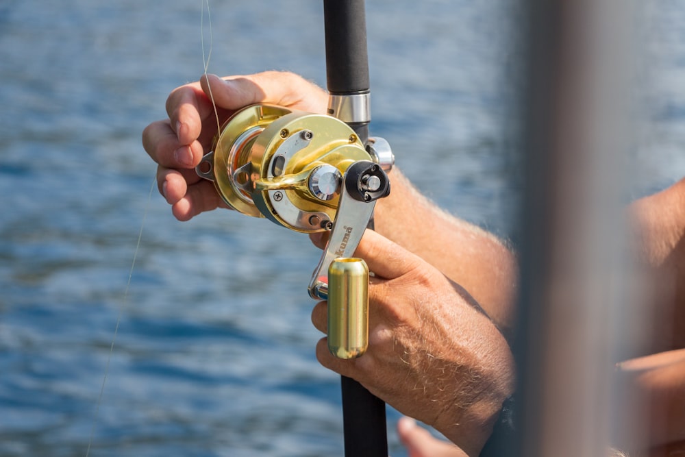 Person holding gold fishing reel photo – Free Lefkada seas Image on Unsplash