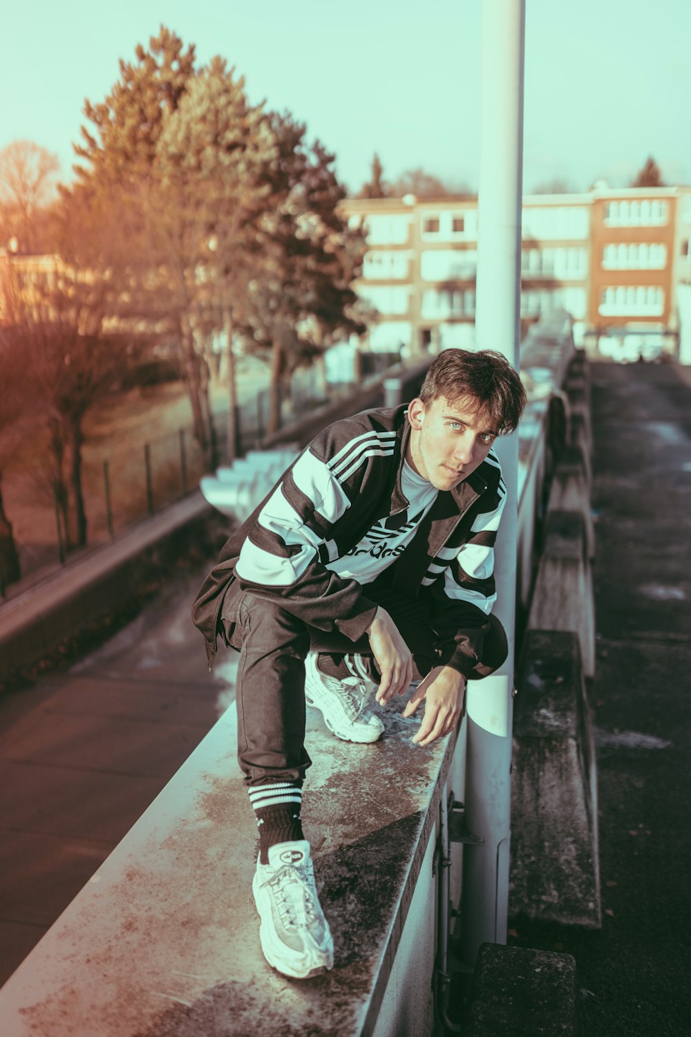 man sitting near railing during daytime