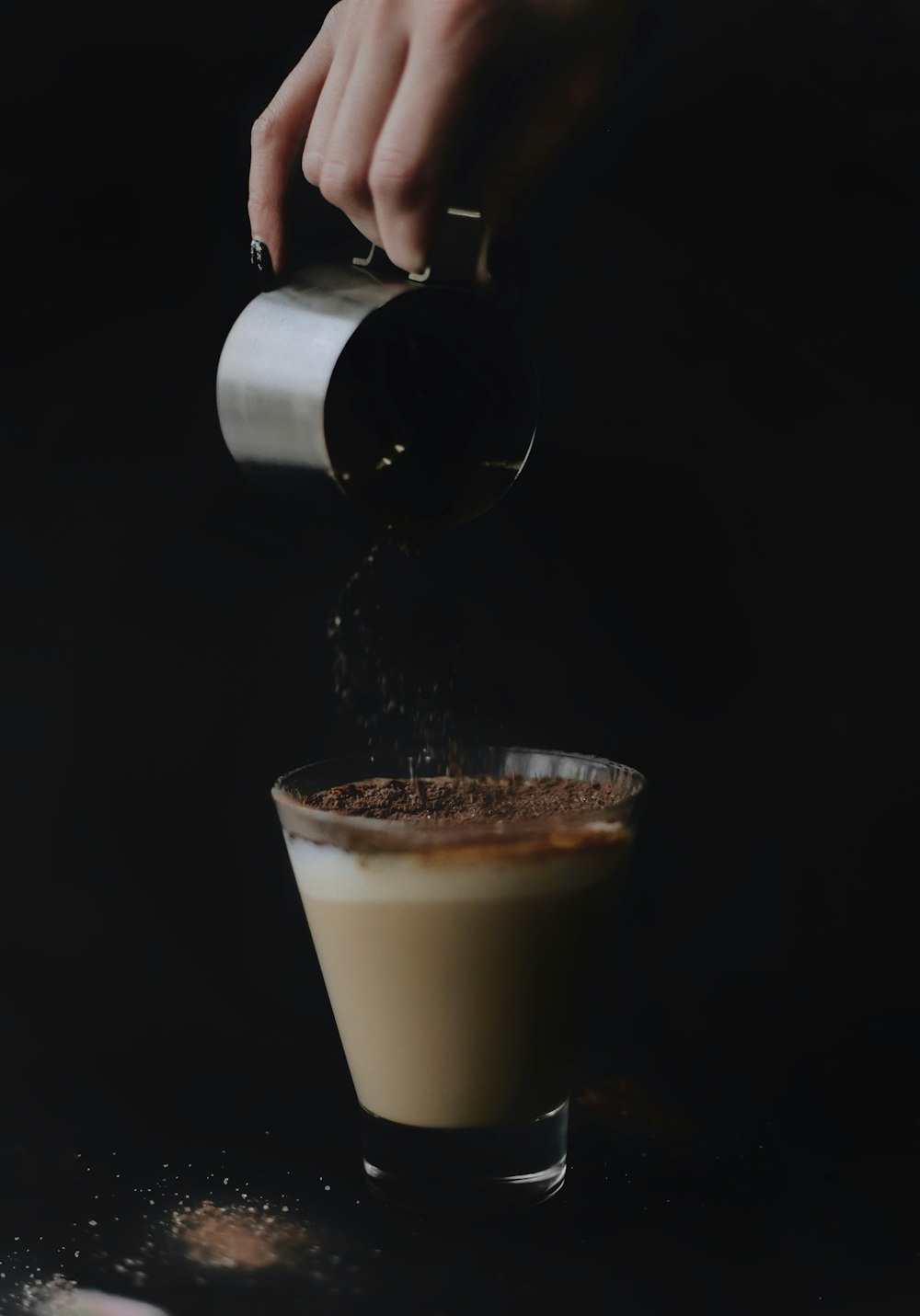 person holding cup pouring on clear glass cup