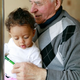 man carrying baby close-up photography