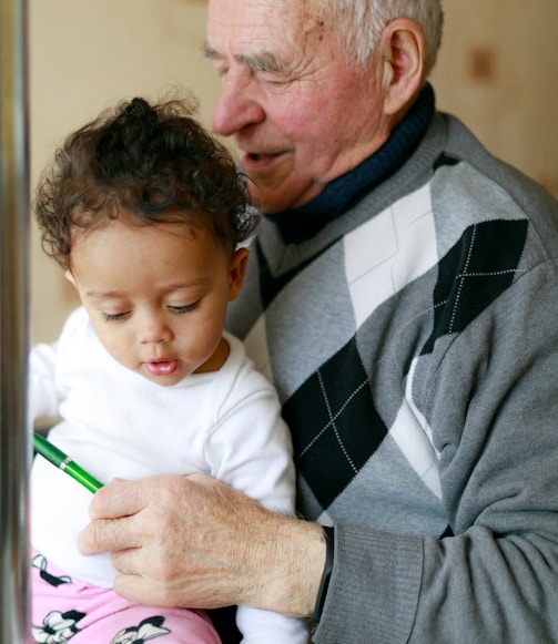 man carrying baby close-up photography