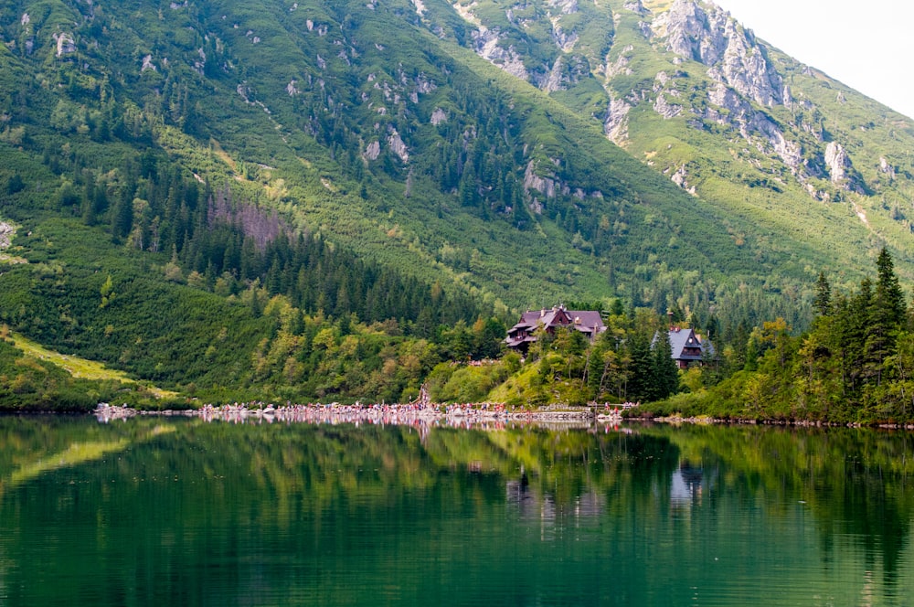 Haus in der Nähe des Sees, umgeben von Bäumen mit Blick auf die Berge