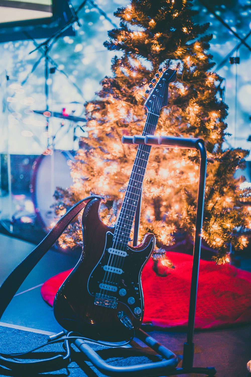 black electric guitar beside holiday tree