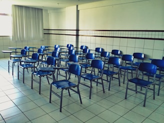 Close-up of a row of polished school chairs and desks arranged neatly in a bright classroom.