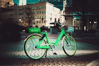 Close-up of a vibrant electric green loop bike parked neatly against a colorful city backdrop.