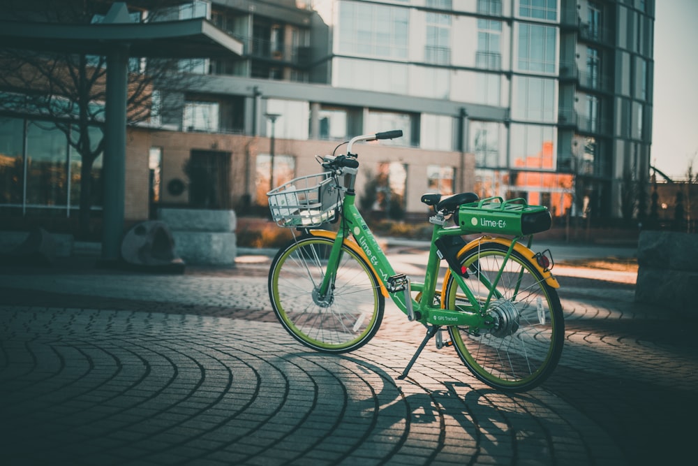 green step-through bicycle parked near building