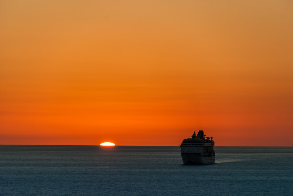 bateau naviguant sur la mer au coucher du soleil