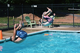 two men jumping on swimming pool
