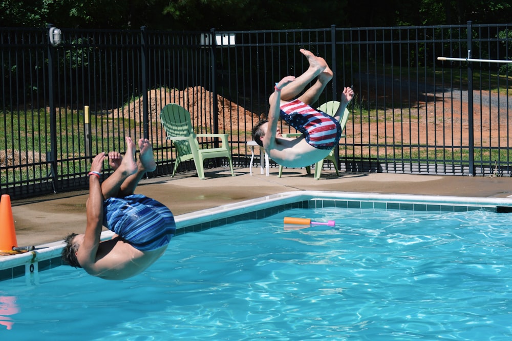 two men jumping on swimming pool