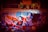 A vibrant graffiti mural with abstract shapes and patterns, featuring swirling designs in red, blue, orange, and black. Above the mural, there are faint images of human faces in a sepia tone, adding an element of intrigue and mystery.