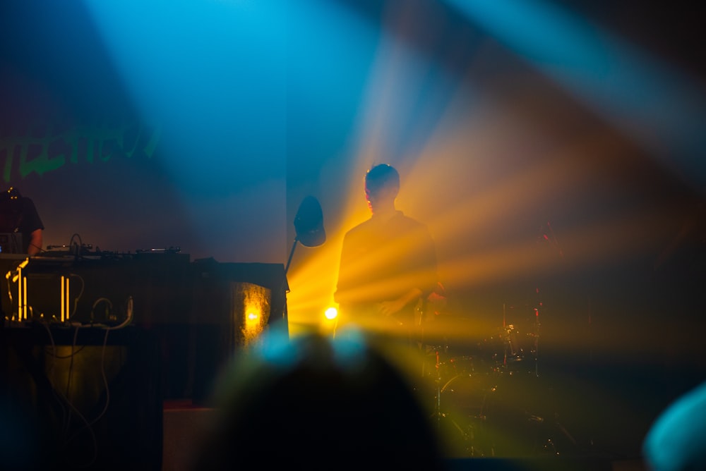 a man standing in front of a microphone on a stage