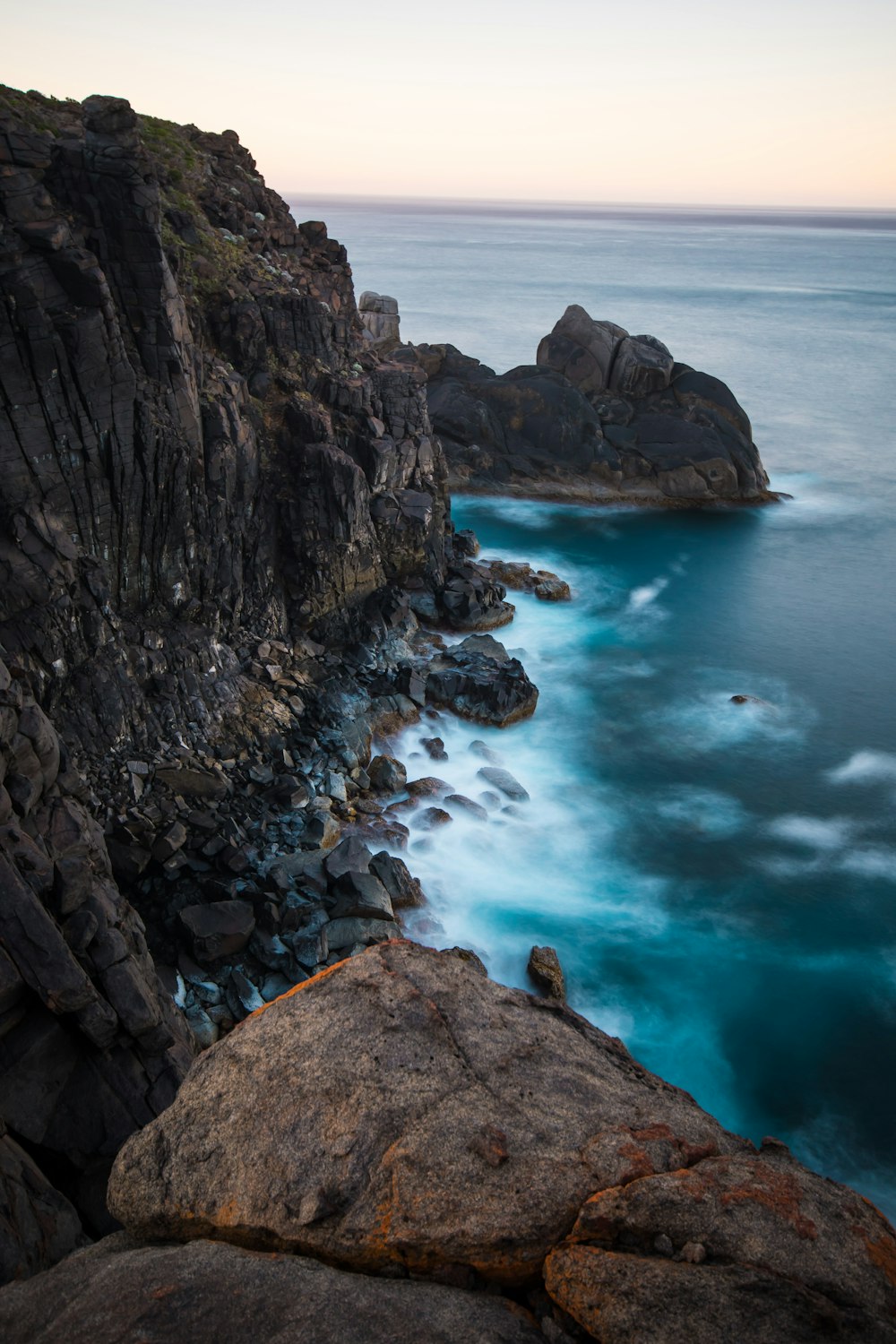 aerial photography of water clashing on brown stone formation